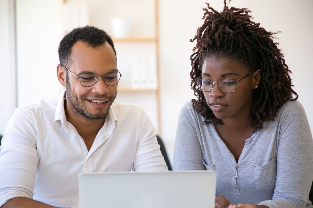 multiethnic colleagues using laptop